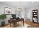 Elegant office with a wooden desk, chandelier lighting, hardwood floors, and a comfortable workspace at 357 Magnolia St, Davidson, NC 28036