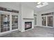 Cozy sunroom with a brick fireplace, tiled floor, skylight, and multiple French doors for natural light at 357 Magnolia St, Davidson, NC 28036