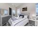 Bright bedroom with neutral tones, patterned bedding, and a scenic view outside the window at 3630 N Davidson St # 4406, Charlotte, NC 28205