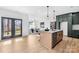 Spacious kitchen overlooking dining area, featuring a kitchen island, green cabinets, and modern appliances at 4011 Brandy Creek Ct, Clover, SC 29710