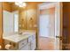 Bathroom with sink and mirror, neutral walls, and wood floors in the hallway at 561 Ambergate Nw Pl, Concord, NC 28027