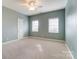 Well-lit bedroom with a ceiling fan and two windows providing natural light at 561 Ambergate Nw Pl, Concord, NC 28027