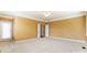 This large bedroom has neutral walls, carpet, and ceiling fan with access to a balcony at 561 Ambergate Nw Pl, Concord, NC 28027