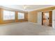 Large bedroom features neutral carpet, walls, lots of light, and an open door at 561 Ambergate Nw Pl, Concord, NC 28027