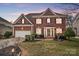 Charming two-story brick home featuring a well-manicured lawn, attached garage and traditional architectural details at 561 Ambergate Nw Pl, Concord, NC 28027