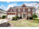 Charming two-story brick home featuring a well-manicured lawn, attached garage and traditional architectural details at 561 Ambergate Nw Pl, Concord, NC 28027