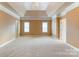 Spacious main bedroom featuring tray ceilings, chandelier, and neutral carpeting at 561 Ambergate Nw Pl, Concord, NC 28027