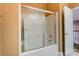 Bathroom featuring a tub and shower combo with glass doors and neutral tile at 561 Ambergate Nw Pl, Concord, NC 28027