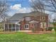 Brick home with screened porch offers views to the sprawling backyard and patio, creating a perfect blend of indoor-outdoor living at 6042 Legacy Cir, Charlotte, NC 28277