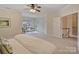 Spacious bedroom with sitting area, neutral carpet, ceiling fan, and access to the upper level at 6042 Legacy Cir, Charlotte, NC 28277