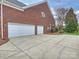 Spacious driveway leads to a well-maintained brick home with a three-car garage and manicured landscaping at 6042 Legacy Cir, Charlotte, NC 28277