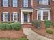 Inviting front entrance showcasing a covered porch, brick steps, and manicured landscaping at 6042 Legacy Cir, Charlotte, NC 28277