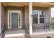 Close-up of front porch with gray door, brick columns, and a decorative monogram at 6361 Willow Farm Dr, Denver, NC 28037