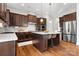 Modern kitchen features dark wood cabinetry, stainless steel appliances, and a spacious island with bar seating at 6361 Willow Farm Dr, Denver, NC 28037