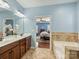 Bathroom with double vanity, soaking tub, and connecting bedroom at 712 English Tudor Ln, Charlotte, NC 28211