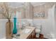 Classic bathroom design with wallpaper, framed art, and decoratively displayed flowers at 725 Plantation Rd, Lancaster, SC 29720