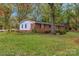 Side view of a brick home with a well-kept lawn and mature trees, offering a serene backyard at 725 Plantation Rd, Lancaster, SC 29720