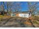 This single-story home features a combination of brick and white siding, a cozy porch, and an expansive driveway at 725 Plantation Rd, Lancaster, SC 29720