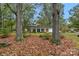 Charming single-story home with a brick facade, surrounded by mature trees and a lush, leafy front yard at 725 Plantation Rd, Lancaster, SC 29720