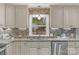 Well-lit kitchen with granite countertops, designer backsplash, stainless steel appliances and a view of the neighborhood at 725 Plantation Rd, Lancaster, SC 29720