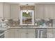 Close-up shot of sink, backsplash, countertops, and cabinetry in updated kitchen at 725 Plantation Rd, Lancaster, SC 29720