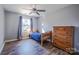 Bedroom featuring hardwood floors, a ceiling fan, and a window with light gray curtains at 7505 Torphin Ct, Charlotte, NC 28269