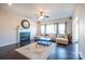 Bright living room with a fireplace, ceiling fan, large sofa and a blue table on a patterned rug at 7505 Torphin Ct, Charlotte, NC 28269