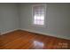 A bright bedroom features hardwood floors and a large window with blinds at 105 W 21St St, Kannapolis, NC 28081