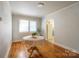 Sunlit dining area with polished hardwood floors, neutral paint, and an archway leading to the kitchen at 105 W 21St St, Kannapolis, NC 28081