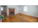 Spacious living room with a decorative brick fireplace, natural light, and gleaming hardwood floors at 105 W 21St St, Kannapolis, NC 28081