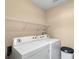 Functional laundry room with a washer, dryer, and overhead shelving for storage at 10628 Hill Point Ct, Charlotte, NC 28262