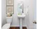 Modern powder room with pedestal sink, toilet, and stylish wall art at 10630 Tuff Ln, Davidson, NC 28036