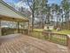 Cozy covered back porch featuring wood floors and a view of the large backyard with storage shed and play set at 11143 Coachman Cir, Charlotte, NC 28277