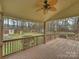 Covered back porch with ceiling fan overlooking a spacious yard with play set and storage shed in the background at 11143 Coachman Cir, Charlotte, NC 28277