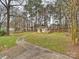 Large backyard with a winding path leading to a shed and a playground, surrounded by mature trees at 11143 Coachman Cir, Charlotte, NC 28277