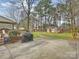 Expansive backyard featuring a storage shed, play set, covered porch and mature trees at 11143 Coachman Cir, Charlotte, NC 28277