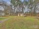 Spacious backyard featuring a play set, storage shed, and lush greenery, perfect for outdoor activities at 11143 Coachman Cir, Charlotte, NC 28277