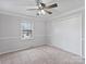 Bedroom with a ceiling fan, carpeted floor, and large window at 11143 Coachman Cir, Charlotte, NC 28277