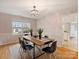 Bright dining room features a modern chandelier, wood table, and a window providing natural light at 11143 Coachman Cir, Charlotte, NC 28277