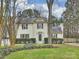 Well-maintained two-story home with white brick, a stone accent, and manicured lawn and garden at 11143 Coachman Cir, Charlotte, NC 28277