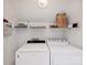 Bright laundry room with white Whirlpool washer and dryer and wire shelving at 11143 Coachman Cir, Charlotte, NC 28277