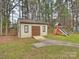 Backyard featuring a shed and a playground, offering ample storage and recreational space at 11143 Coachman Cir, Charlotte, NC 28277