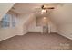 Finished attic with neutral walls, plush carpet, ceiling fan and staircase access at 12016 Regent Ridge Ln, Charlotte, NC 28278