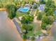 Aerial view of a community pool and lake access with a beach area and mature trees at 12104 Baywoods Dr, Tega Cay, SC 29708