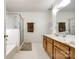 Bright bathroom with glass shower door, double vanity, and white tile at 12104 Baywoods Dr, Tega Cay, SC 29708