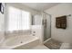 Bright bathroom featuring a shower, soaking tub, and large window at 12104 Baywoods Dr, Tega Cay, SC 29708