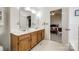 Spacious bathroom featuring double sinks, wood vanity, and white tile flooring at 12104 Baywoods Dr, Tega Cay, SC 29708