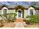 Close up of the front entrance featuring a blue door, brick steps, and manicured bushes at 12104 Baywoods Dr, Tega Cay, SC 29708