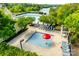 Aerial view of community pools including a ' pool and lap pool with surrounding trees and lake view at 12104 Baywoods Dr, Tega Cay, SC 29708