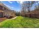 Beautiful backyard with a brick wall, patio area and green lawn and mature trees at 1604 Windy Ridge Rd, Charlotte, NC 28270